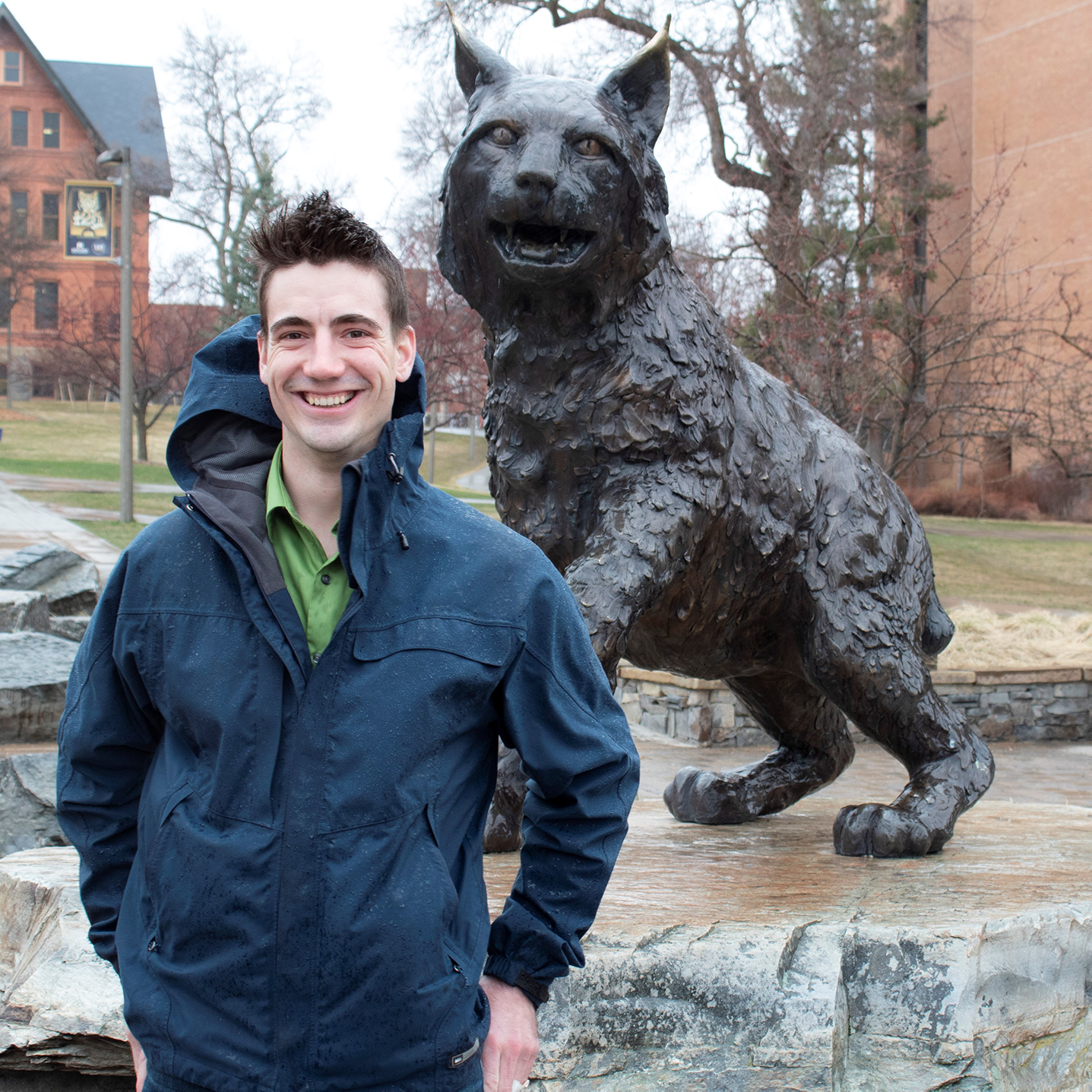 a picture of nathaniel infront of champ the bobcat