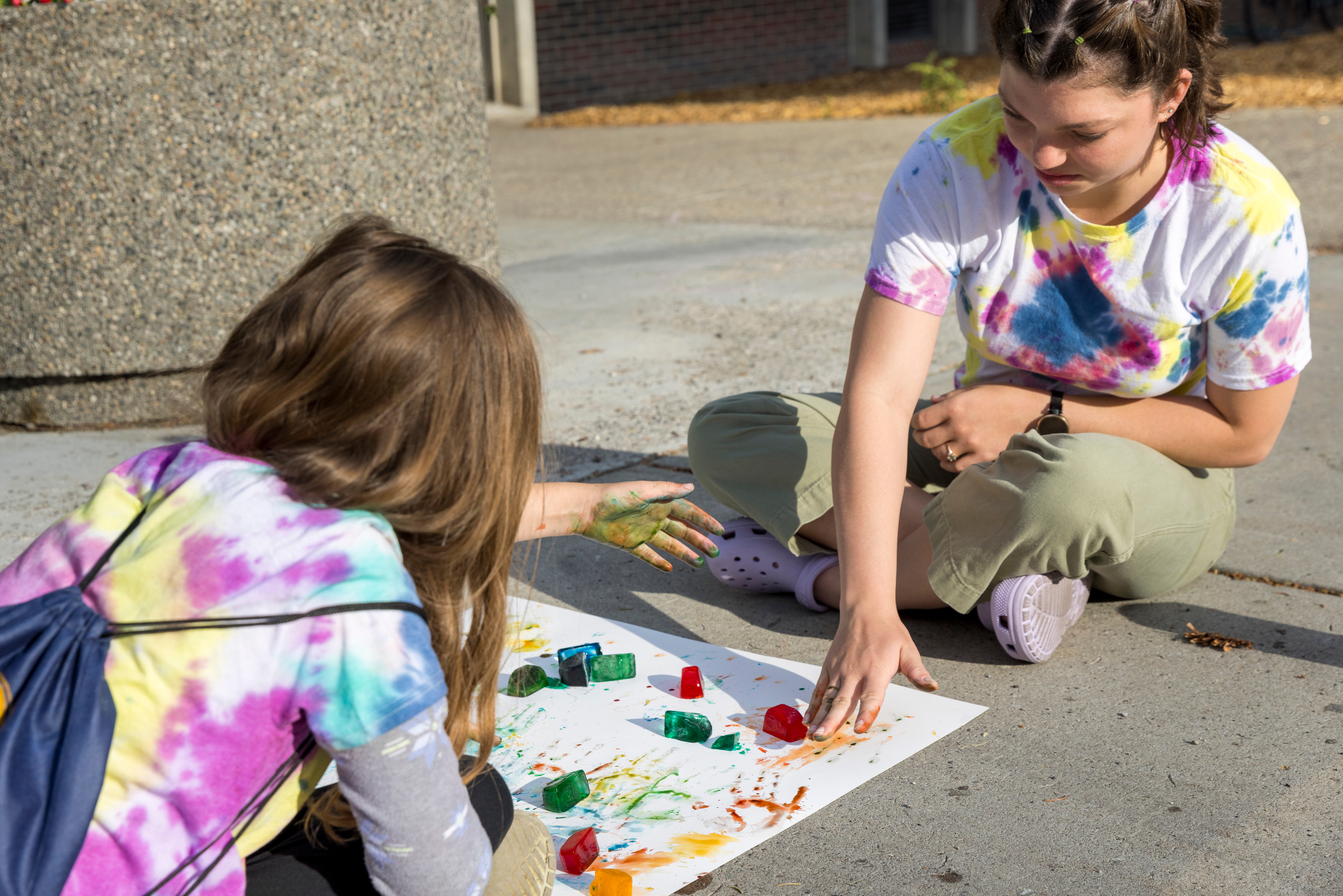 MSU student helps an elementary student paint at an inclusive community camp.