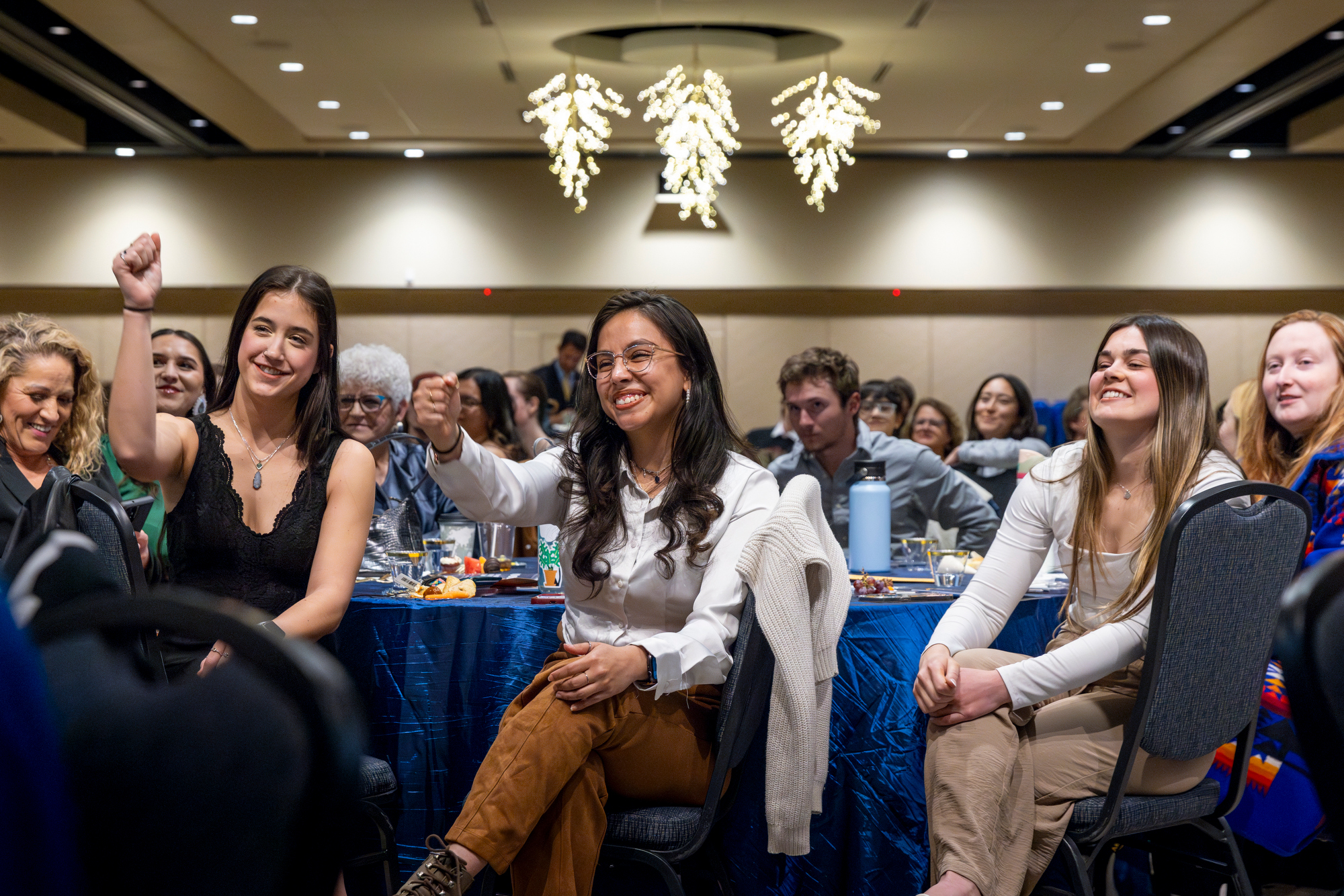 Three students sitting in the crowd at the Day of Student Recognition