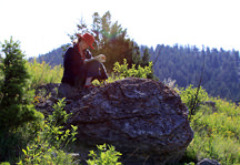 Photo: Student Reading on Rock